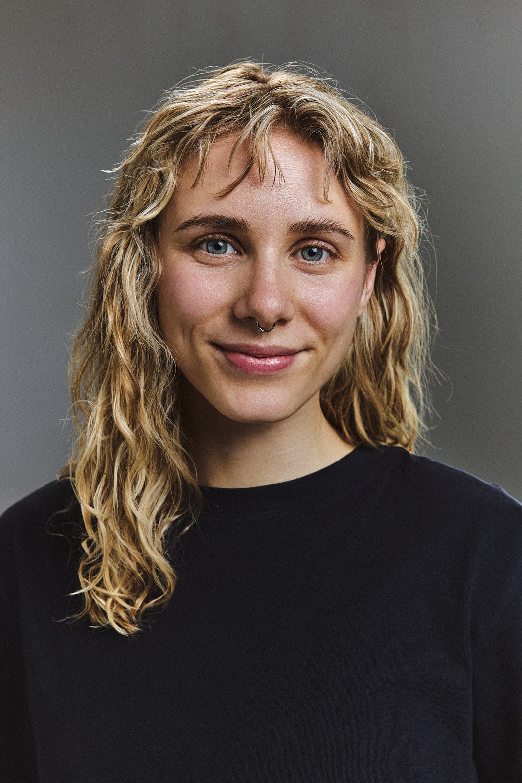Bewerbungsfoto im Studio vor grauem Hintergrund