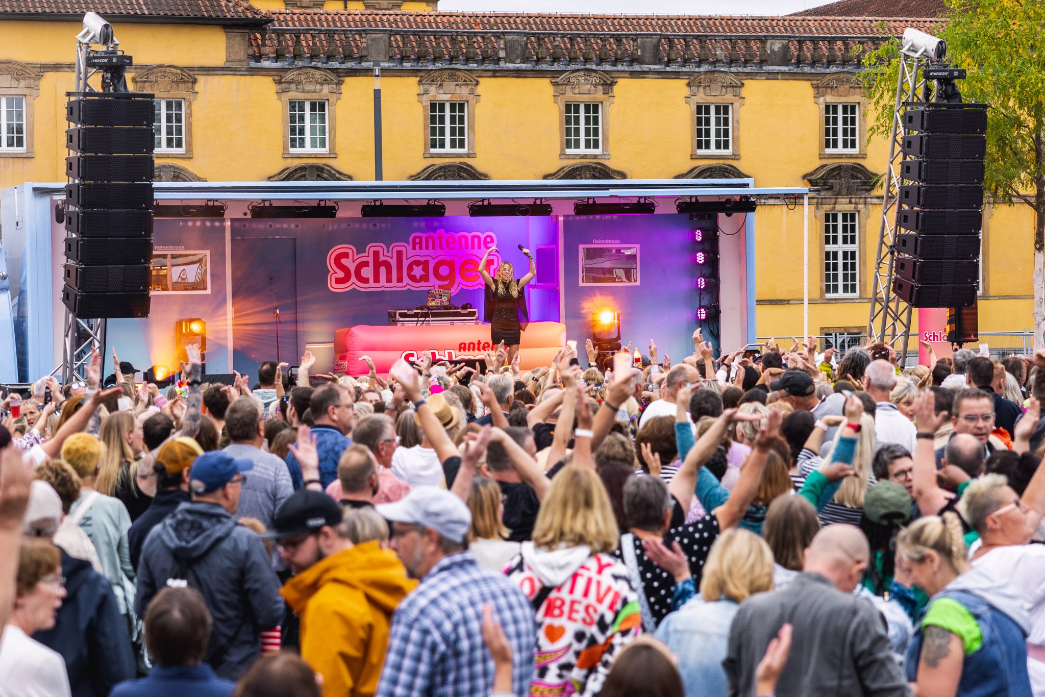Volle Bühne von Antenne Schlager vor dem Schloss, Publikum mit erhobenen Händen