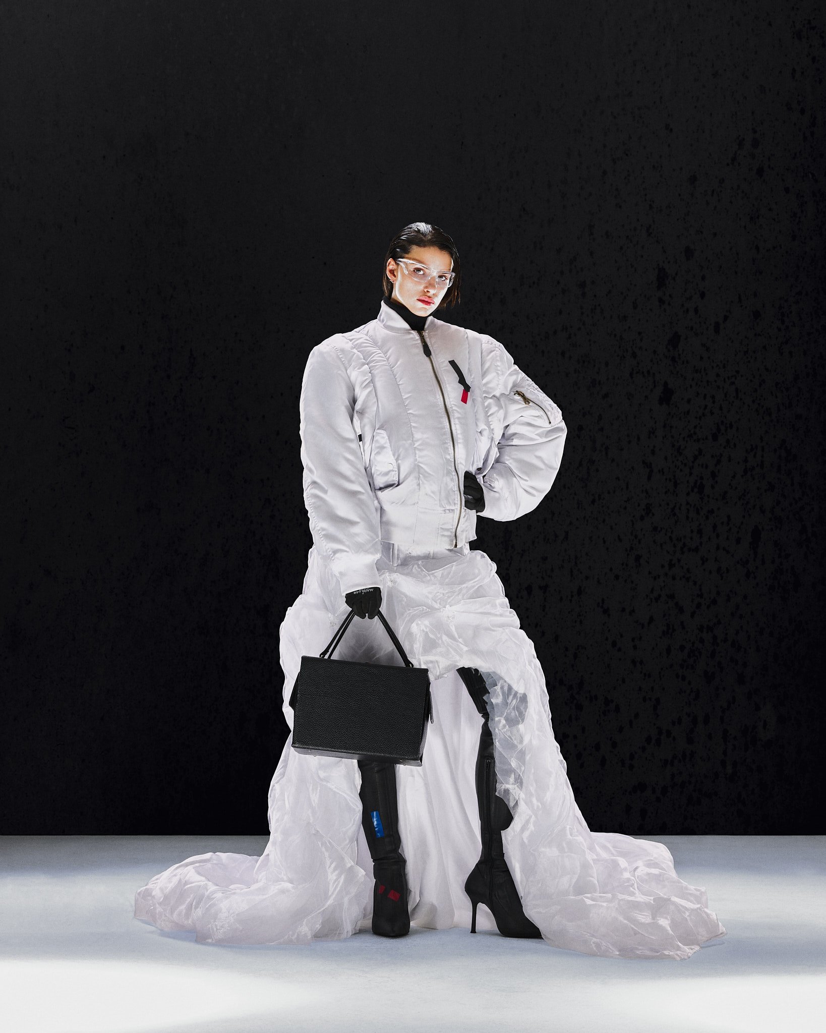 Weiße Steppjacke mit gelagertem Rock und schwarzer Tasche